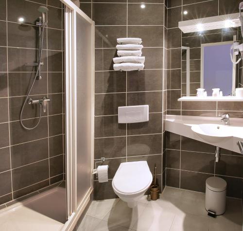 ein Bad mit einem WC, einem Waschbecken und einer Dusche in der Unterkunft HOTEL PARIS PACIFIC VILLEJUIF- INSTITUT GUSTAVE ROUSSY ORLY RUNGIS BUS 131 Direct PARIS in Villejuif