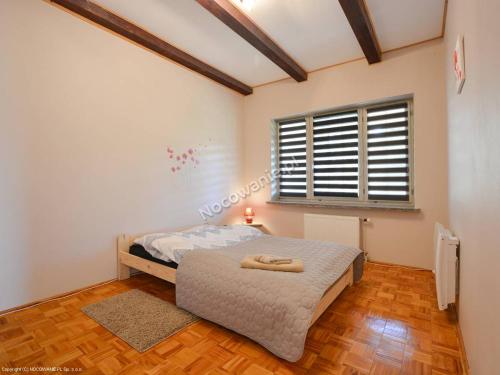 a bedroom with a bed and a window at Apartamenty Rownia in Ustrzyki Dolne