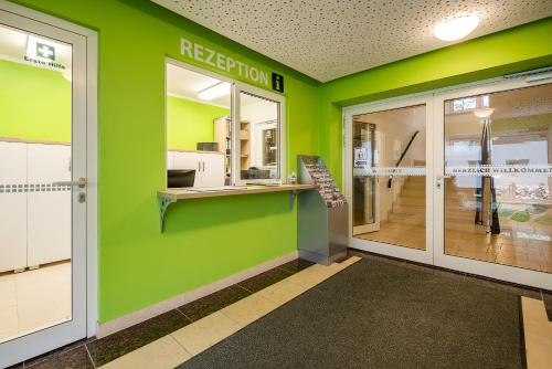 a green wall in a room with a door at Hotel City Green Berlin in Berlin