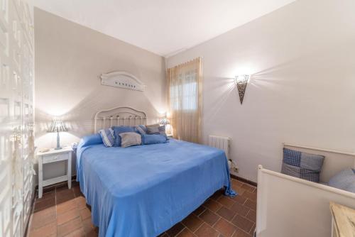 ein Schlafzimmer mit einem blauen Bett und einer weißen Wand in der Unterkunft Apartment Diana in L'Escala