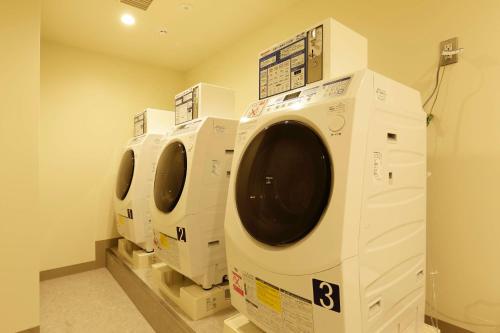a row of white washing machines in a laundry room at WeBase TAKAMATSU in Takamatsu