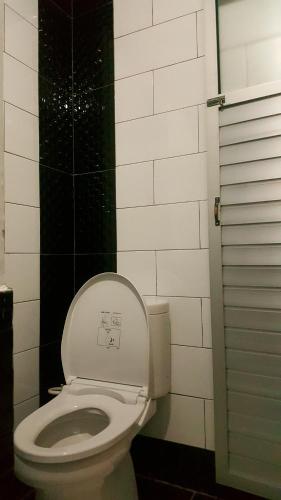 a bathroom with a toilet with the lid up at HOTEL SEGARA MANDALA in Negara