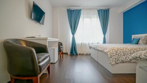 una camera con letto, scrivania e sedia di Coroni Residence a Braşov