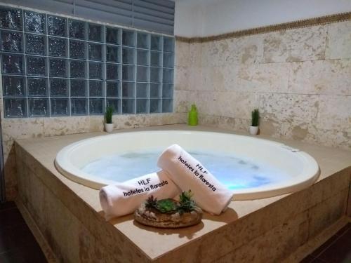 Santa Maria de Leyva hotel boutique في فيلا دي ليفا: حمام مع حوض به مناشف