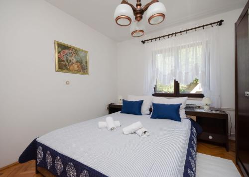 a bedroom with a large bed with blue and white sheets at Apartment Katarina in Crikvenica