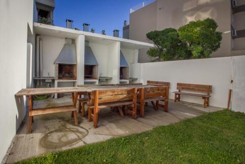 a wooden table and benches in front of a building at MitreCity in Ostende