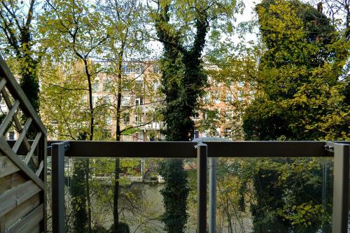 a gate with trees and a building in the background at Hotel Mosaic City Centre in Amsterdam