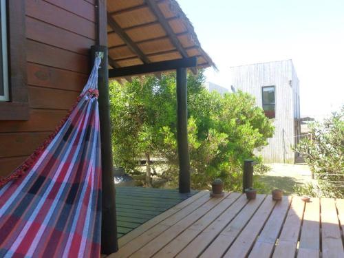 a hammock on the porch of a house at Excelente Cabaña Cumbre del Diablo 2 in Punta Del Diablo