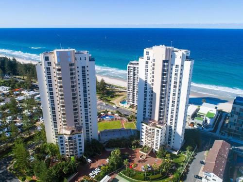 two tall white buildings next to the beach at Xanadu Resort in Gold Coast