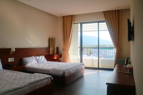 um quarto de hotel com duas camas e uma varanda em My Ca Hotel em Cam Ranh