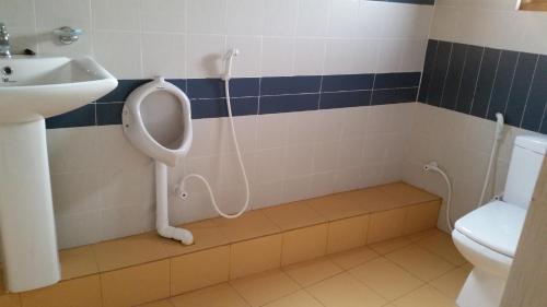 ein Badezimmer mit einem Urinal, einem Waschbecken und einem WC in der Unterkunft Chelli Homestay in Negombo