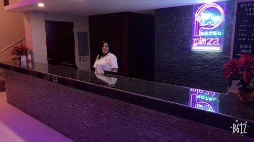 a woman standing at the counter of a bar at Hotel Plaza Arteaga in Monterrey