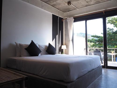 a bedroom with a large white bed with a large window at Samatha Bed & Breakfast in Ko Tao