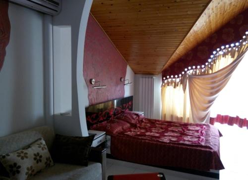 a bedroom with a red bed and a window at Racu in Komrat