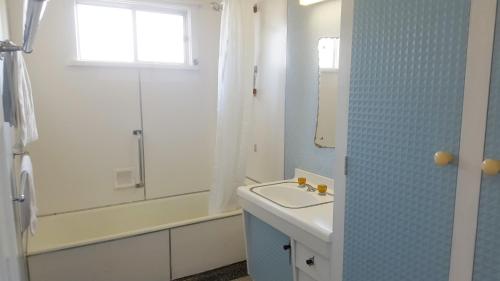 a bathroom with a sink and a shower and a mirror at Sailors Rest in Brisbane