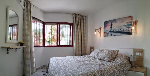 1 dormitorio con 1 cama y 2 ventanas en Sol y Relax, Lubina Sol, en Mijas Costa