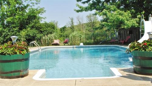 ein Pool in einem Hof mit zwei Topfpflanzen in der Unterkunft Pretty River Valley Country Inn in Nottawa