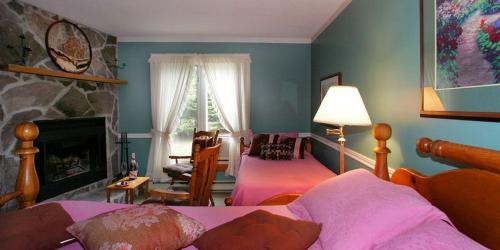 a bedroom with a bed and a living room with a fireplace at Pretty River Valley Country Inn in Nottawa