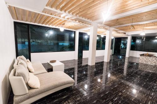 a living room with a couch and some windows at The Unique Resident Chiang Rai in Chiang Rai