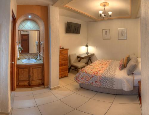 a bedroom with a bed and a bathroom with a sink at Hotel Santa Paula in Taxco de Alarcón