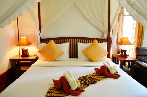 ein Schlafzimmer mit einem Bett mit zwei Handtüchern darauf in der Unterkunft Sayang Beach Resort Koh Lanta in Ko Lanta