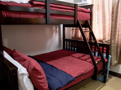 a bunk bed with red and blue pillows on it at 5H Tower C Manhattan Heights Cubao QC in Manila
