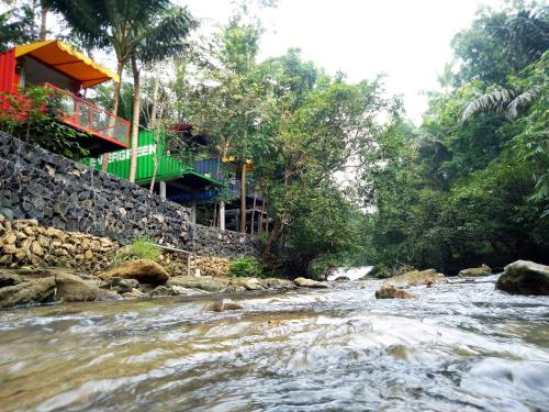 a river with a building on the side of it at Hau Eco Lodges Citumang Pangandaran in Pangandaran