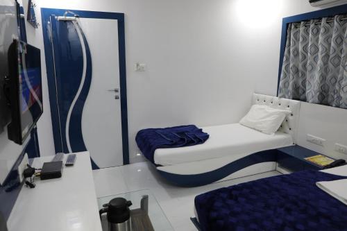 a small room with two beds and a desk at Hotel Pearl in Navi Mumbai