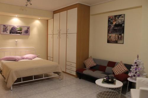 a bedroom with a bed and a couch at Cozy studio apartment in PIREUS in Piraeus