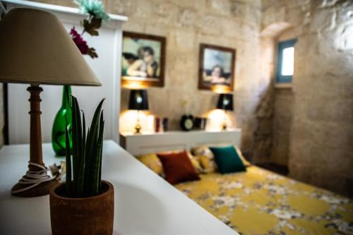 a room with a table with a lamp and a couch at Cosy Townhouse in Historic Centre in Birgu