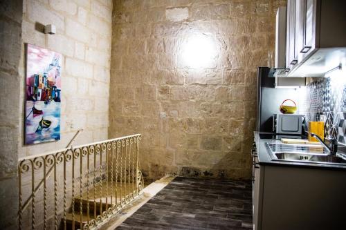 una cucina con lavello e microonde di Cosy Townhouse in Historic Centre a Birgu (Vittoriosa)