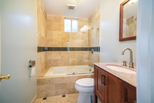 a bathroom with a tub and a toilet and a sink at Stylish 2 Bed & 2 Bath at the Heart of Hollywood with Free Parking - One Car only in Los Angeles