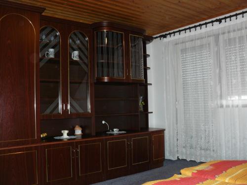 a large wooden cabinet with a sink in a bedroom at Zsuzsi Apartman in Zalakaros