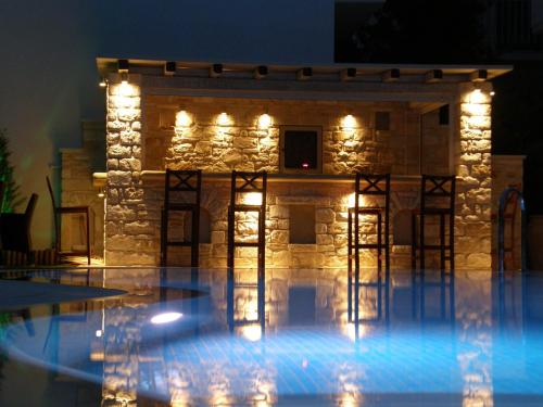 a house with lights in a pool at night at Anna Platanou Hotel in Parikia