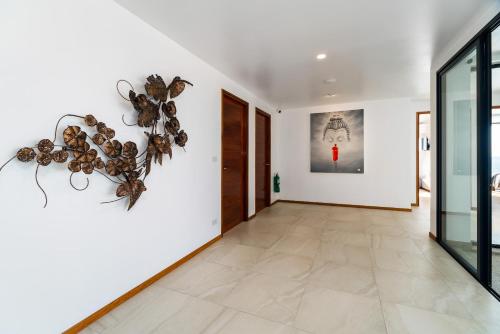 a hallway with white walls and a tiled floor at Fabuleuse villa Alizés vue mer, avec Staff et véhicule 4x4 in Ban Bang Po