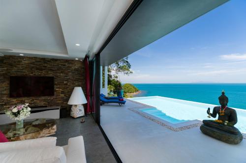 a living room with a view of the ocean at Fabuleuse villa Alizés vue mer, avec Staff et véhicule 4x4 in Ban Bang Po
