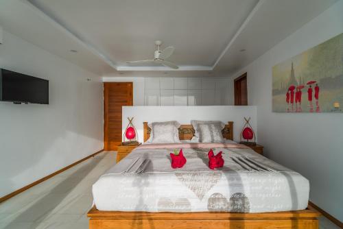 a bedroom with a bed with two red cats on it at Fabuleuse villa Alizés vue mer, avec Staff et véhicule 4x4 in Ban Bang Po
