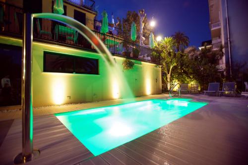 a swimming pool at night with a water fountain at Hotel Villa Anita in Santa Margherita Ligure