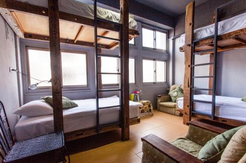 a room with three bunk beds and a couch at Good Farming Day B&B in Chishang