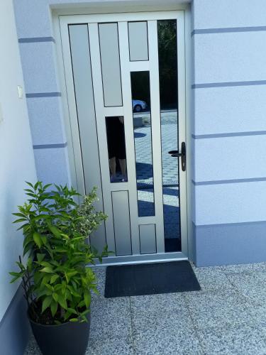 an open door to a house with a potted plant at Private Home Rifat in Dubrave Gornje