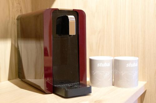 a coffee maker and two coffee cups on a counter at Haus Steinbock in Neustift im Stubaital