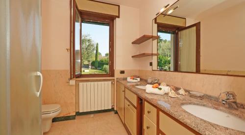 サン・フェリーチェ・デル・ベナーコにあるVilla Sul Gardaのバスルーム(洗面台、トイレ、鏡付)