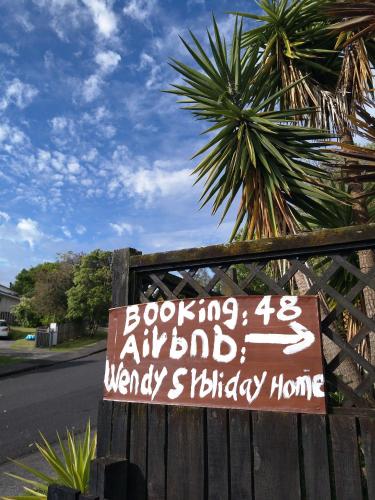 a sign is posted on a wooden fence at Wendy's Holiday Home in Auckland