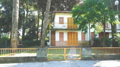 a house with orange doors and a fence in front at Villetta Logonovo in Lido di Spina