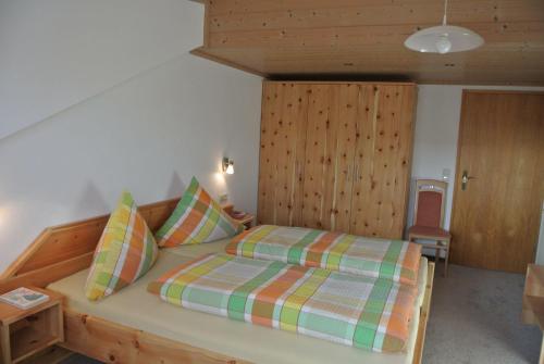 1 dormitorio con cama y cabecero de madera en Ferienwohnung Schlossberg en Hopferau