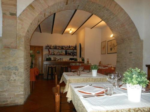 una sala da pranzo con due tavoli e un arco di Agriturismo La Ginestrella a Civitella D'Arna