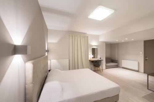 a bedroom with a white bed and a desk at Castello Hotel in Rio