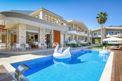 a swimming pool with two swans in a house at Lobelia Luxury Suites in Chrysi Ammoudia