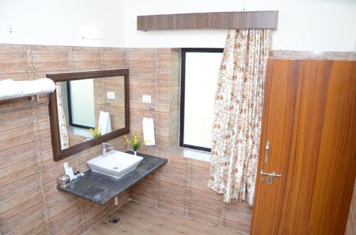 un baño con lavabo y espejo en Motibagh Resort, en Sawāi Mādhopur