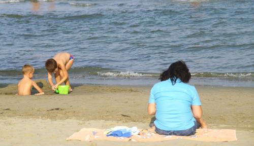 a group of people playing in the sand at the beach at Villetta Logonovo in Lido di Spina